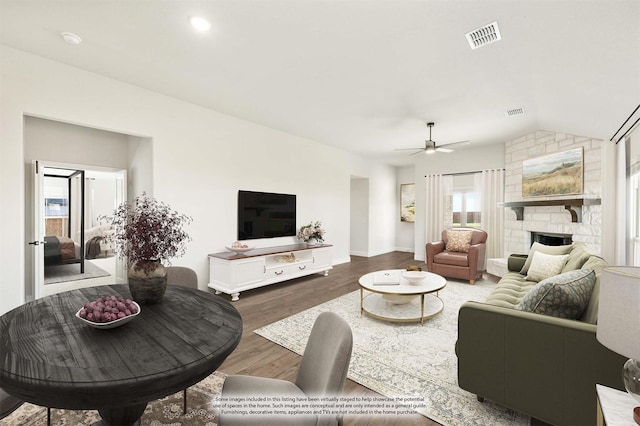 living room with a fireplace, ceiling fan, dark hardwood / wood-style flooring, and vaulted ceiling