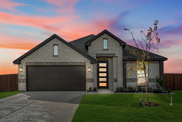 view of front facade with a yard and a garage