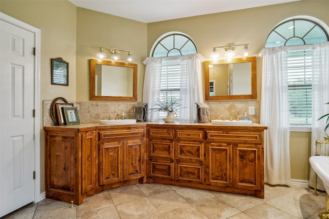 bathroom featuring tile patterned flooring, tasteful backsplash, and dual bowl vanity