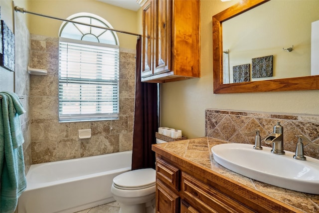 full bathroom with tile patterned flooring, shower / bath combo with shower curtain, toilet, and vanity