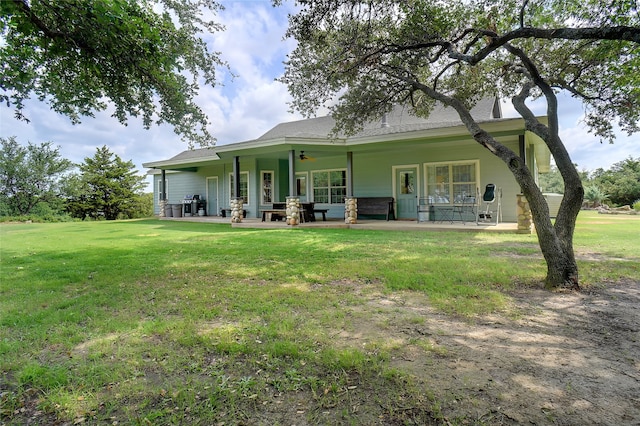 back of house with covered porch and a lawn