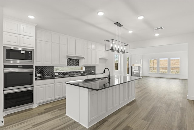3104 Summer Rain Ln, Anna, TX 75409 - kitchen with stainless steel appliances, dark countertops, decorative backsplash, white cabinets, and light wood-style flooring