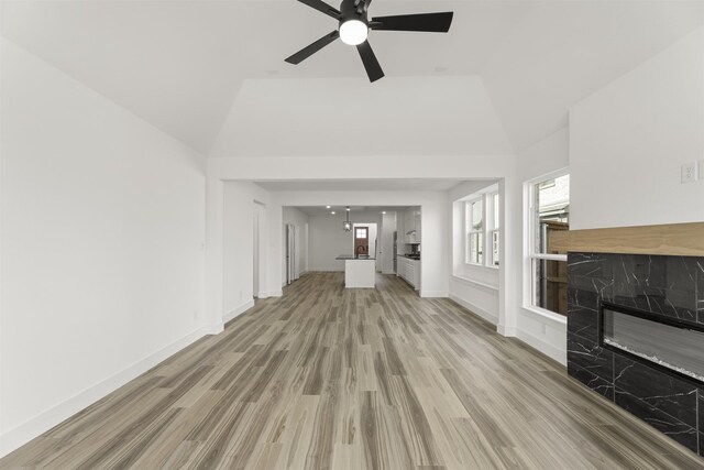 3104 Summer Rain Ln, Anna, TX 75409 - unfurnished living room with a high end fireplace, light wood-type flooring, a ceiling fan, and lofted ceiling