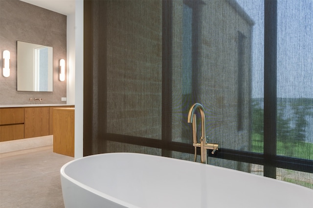 bathroom with a bathing tub, vanity, and decorative backsplash