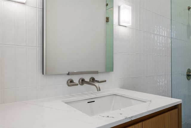 bathroom with vanity, tasteful backsplash, and tile walls