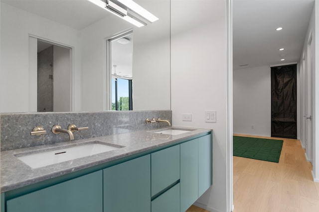 bathroom with wood-type flooring, vanity, and backsplash