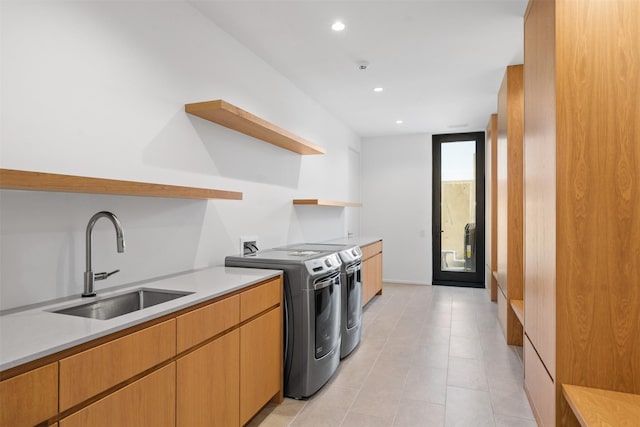 kitchen featuring expansive windows, sink, and washing machine and clothes dryer