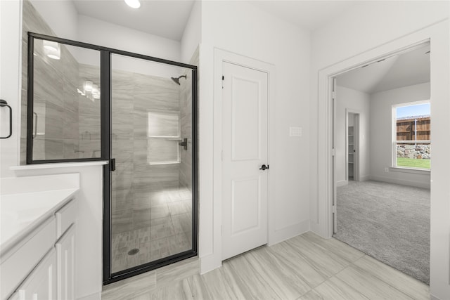 bathroom with a shower with shower door and vanity