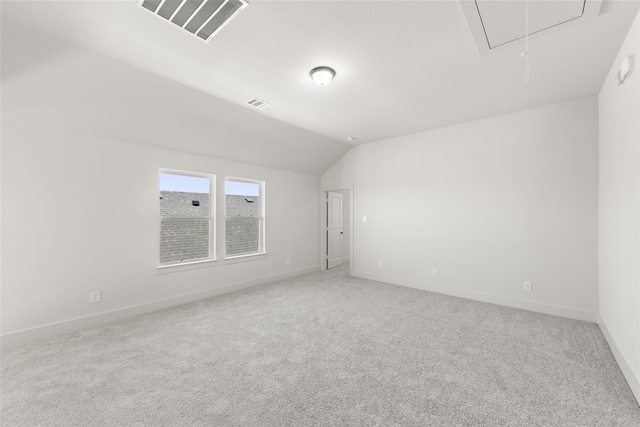 carpeted spare room featuring vaulted ceiling