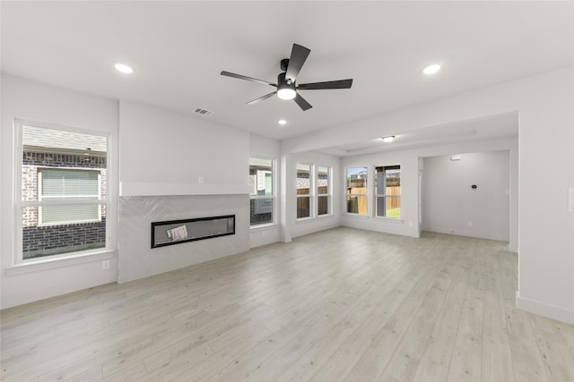 unfurnished living room featuring ceiling fan and light wood-type flooring