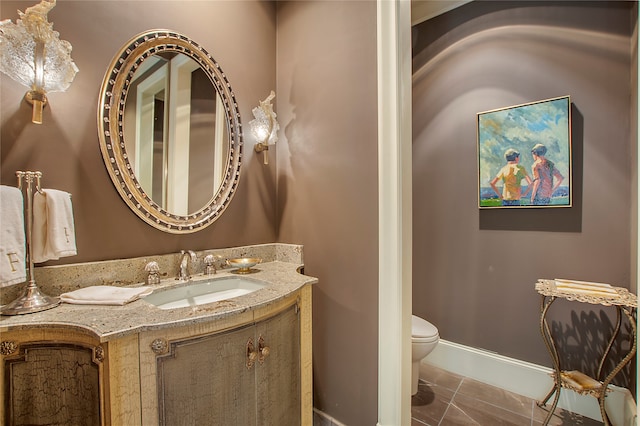 bathroom with toilet, tile patterned flooring, and vanity