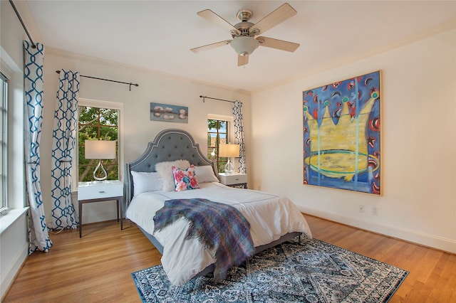 bedroom featuring light wood-type flooring, ceiling fan, and crown molding