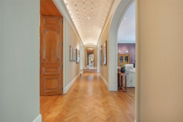 corridor with crown molding and light parquet flooring