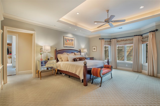 carpeted bedroom with ceiling fan, a tray ceiling, and crown molding