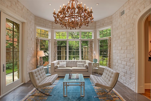 sunroom featuring a chandelier and a healthy amount of sunlight