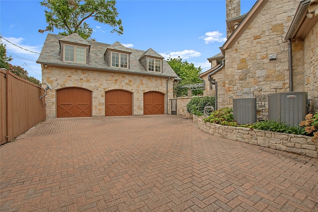 view of side of property with a garage and central AC unit