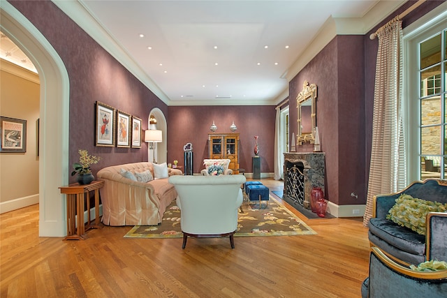 living room with crown molding and light hardwood / wood-style floors