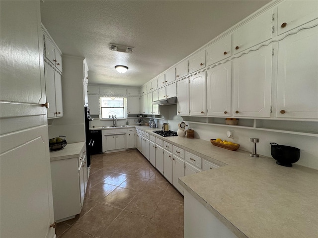 kitchen featuring sink, white cabinetry, gas stovetop, a textured ceiling, and tile patterned floors