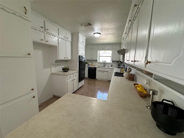 kitchen with black dishwasher, sink, white cabinets, tile patterned flooring, and a textured ceiling