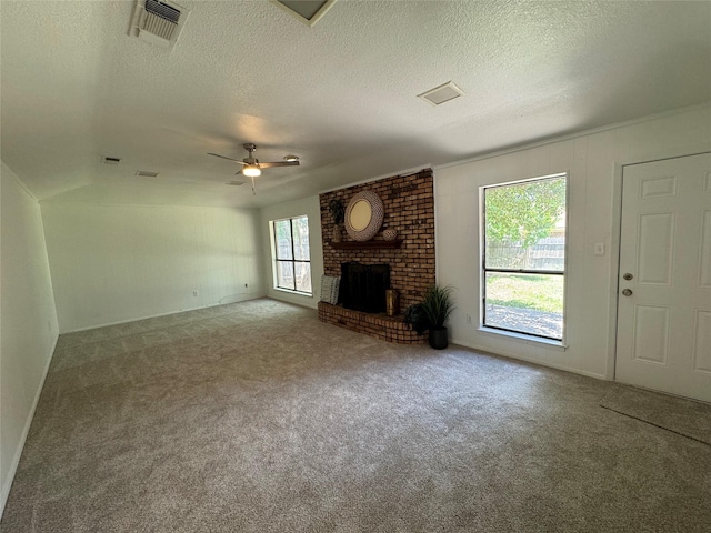 unfurnished living room with ceiling fan, a fireplace, carpet floors, and a textured ceiling