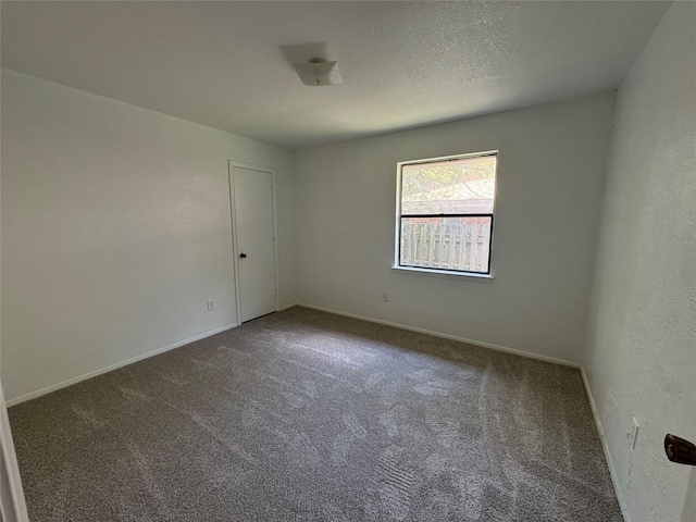 carpeted spare room with a textured ceiling