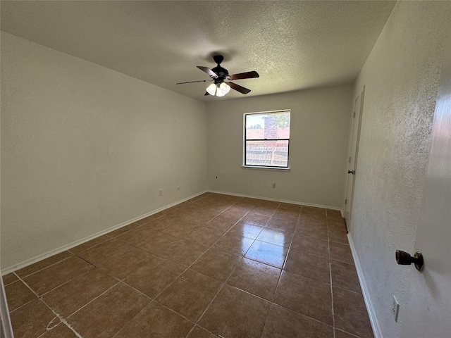 tiled empty room featuring ceiling fan and a textured ceiling