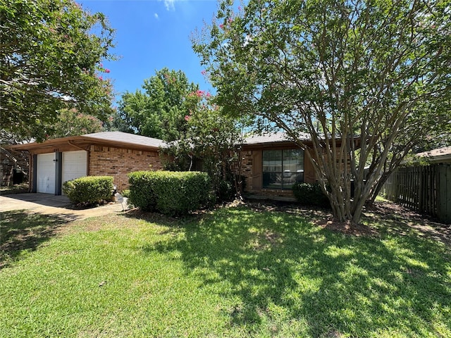 ranch-style home featuring a garage and a front lawn