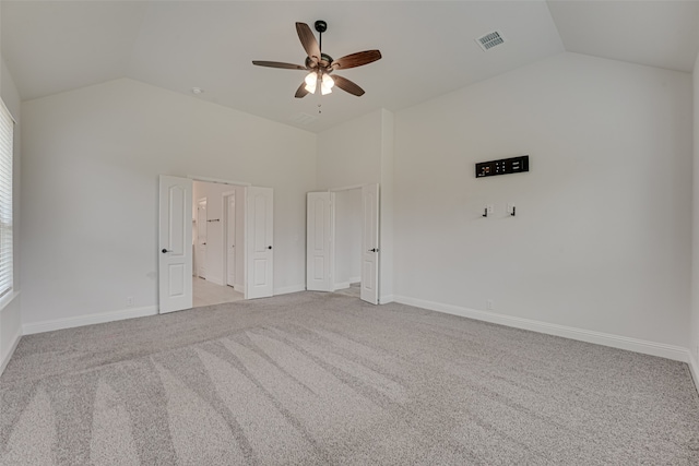 empty room with light carpet, high vaulted ceiling, and ceiling fan