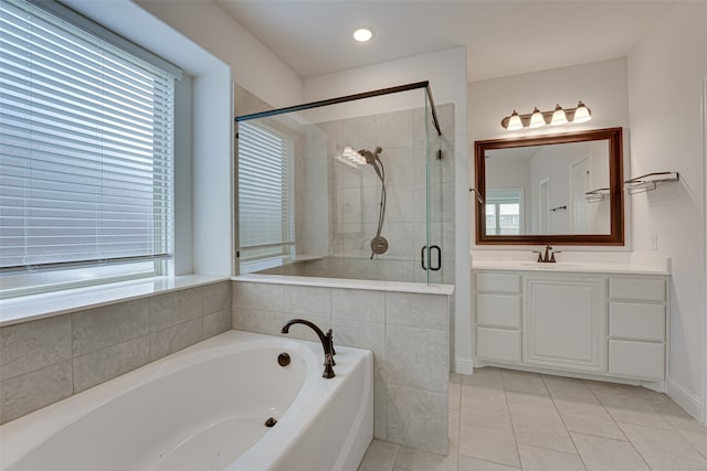 bathroom with tile patterned floors, plenty of natural light, plus walk in shower, and vanity