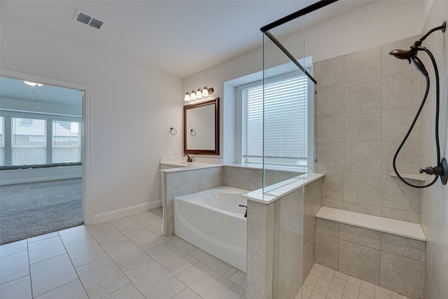 bathroom featuring tile patterned floors, vanity, plus walk in shower, and a healthy amount of sunlight