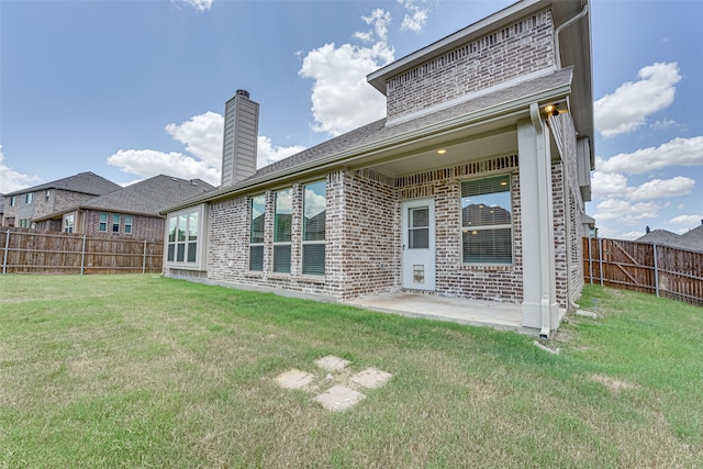 rear view of property with a yard and a patio