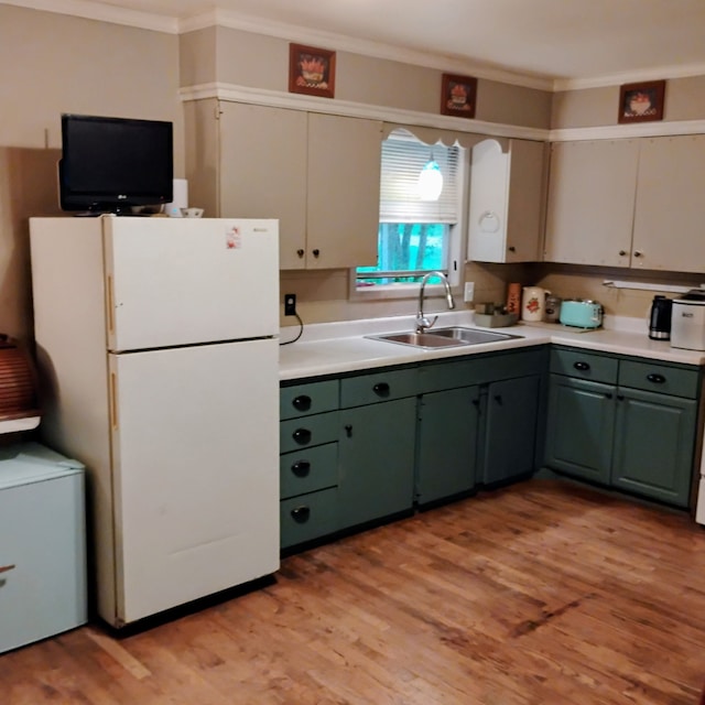 308 County Road 1296, Morgan, TX 76671 - kitchen featuring freestanding refrigerator, ornamental molding, light countertops, light wood-style flooring, and green cabinetry