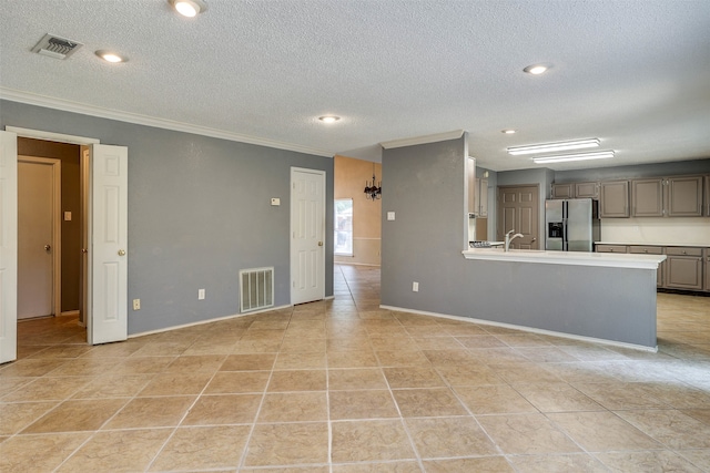 kitchen with stainless steel fridge, ornamental molding, a textured ceiling, and light tile patterned floors