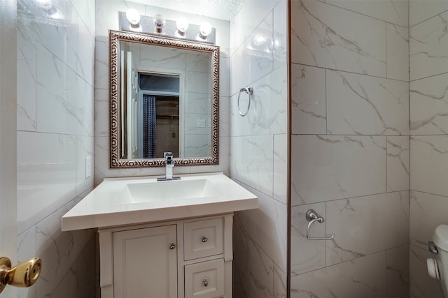 bathroom featuring tile walls, toilet, and vanity