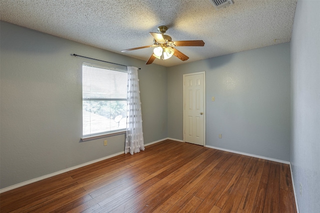 empty room with a textured ceiling, hardwood / wood-style flooring, and ceiling fan