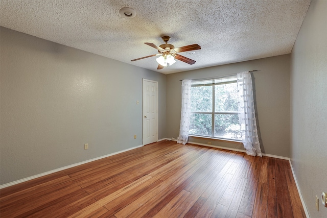 spare room featuring hardwood / wood-style flooring, a textured ceiling, and ceiling fan