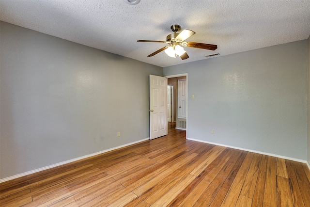 empty room with a textured ceiling, ceiling fan, and hardwood / wood-style floors