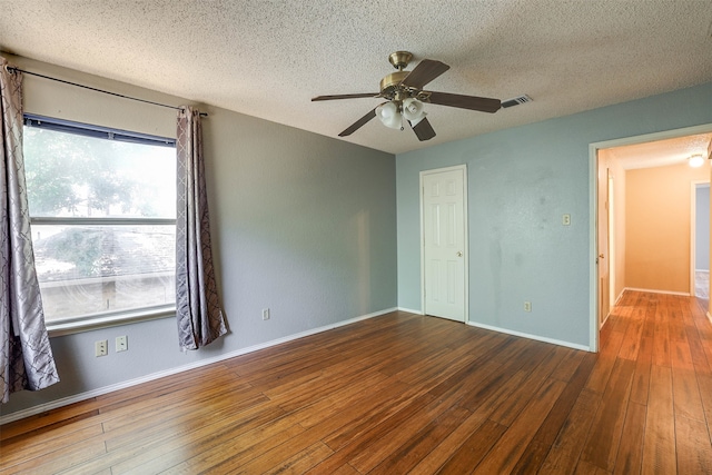 empty room with a textured ceiling, ceiling fan, and hardwood / wood-style floors