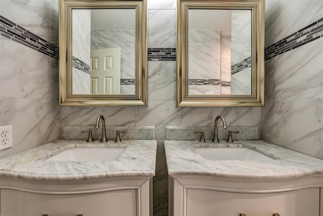 bathroom featuring a textured ceiling, tile walls, and double vanity