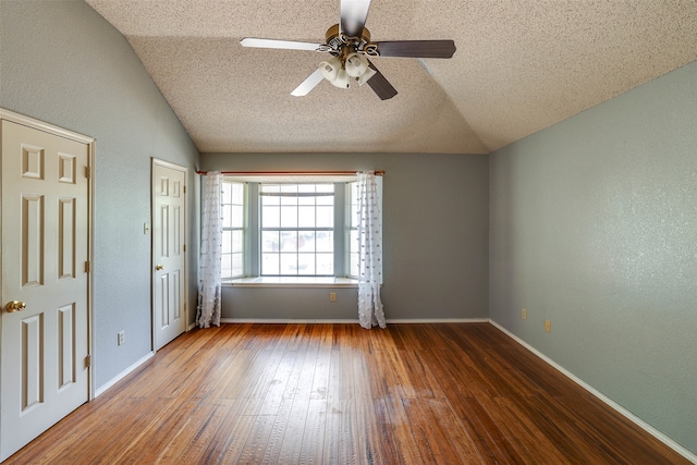 unfurnished room with ceiling fan, wood-type flooring, vaulted ceiling, and a textured ceiling