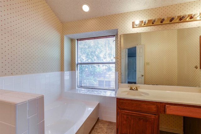 bathroom featuring vanity, tile walls, a textured ceiling, lofted ceiling, and a bath