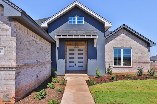 property entrance featuring a lawn and french doors