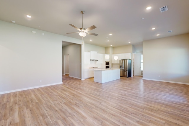 unfurnished living room featuring ceiling fan and light hardwood / wood-style flooring