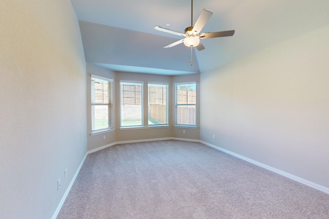 carpeted spare room featuring ceiling fan and vaulted ceiling