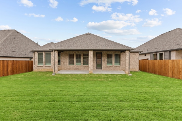 rear view of property with a lawn and a patio area