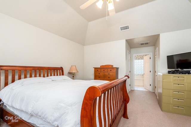 bedroom featuring lofted ceiling, light carpet, ensuite bathroom, and ceiling fan