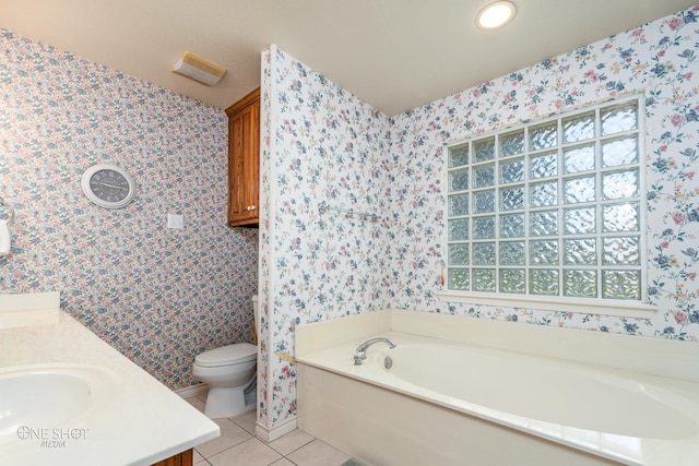 bathroom with vanity, tile patterned floors, a tub to relax in, and toilet