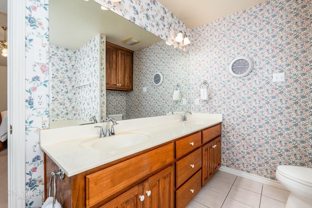 bathroom featuring toilet, tile patterned floors, and double sink vanity