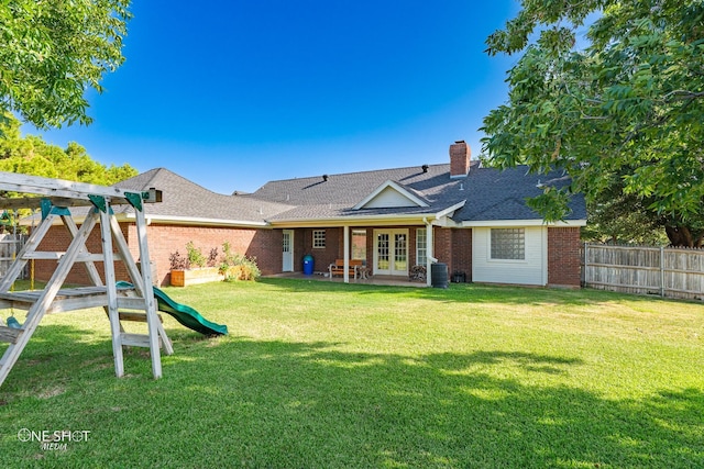 back of house featuring central air condition unit, french doors, and a yard