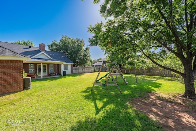 view of yard featuring central air condition unit, a playground, and french doors